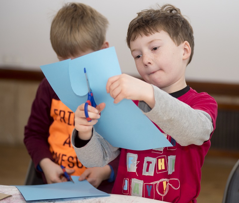 two boys cutting paper